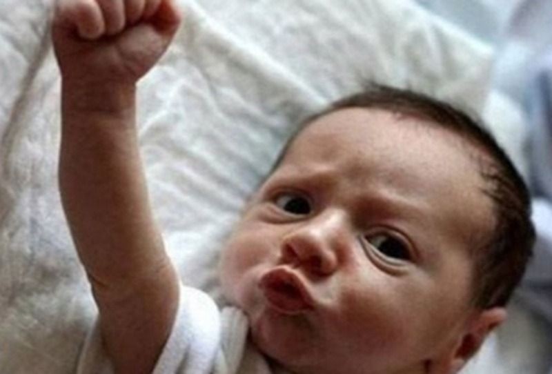 Meme em bé với biểu cảm nắm chặt tay thể hiện sự quyết tâm